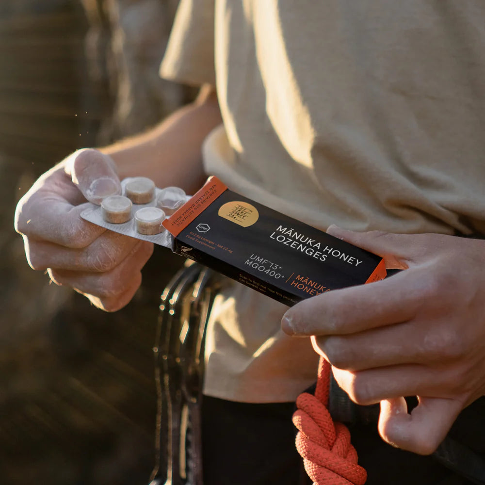 person står med en æske TRUE HONEY CO. Manuka Sugetabletter