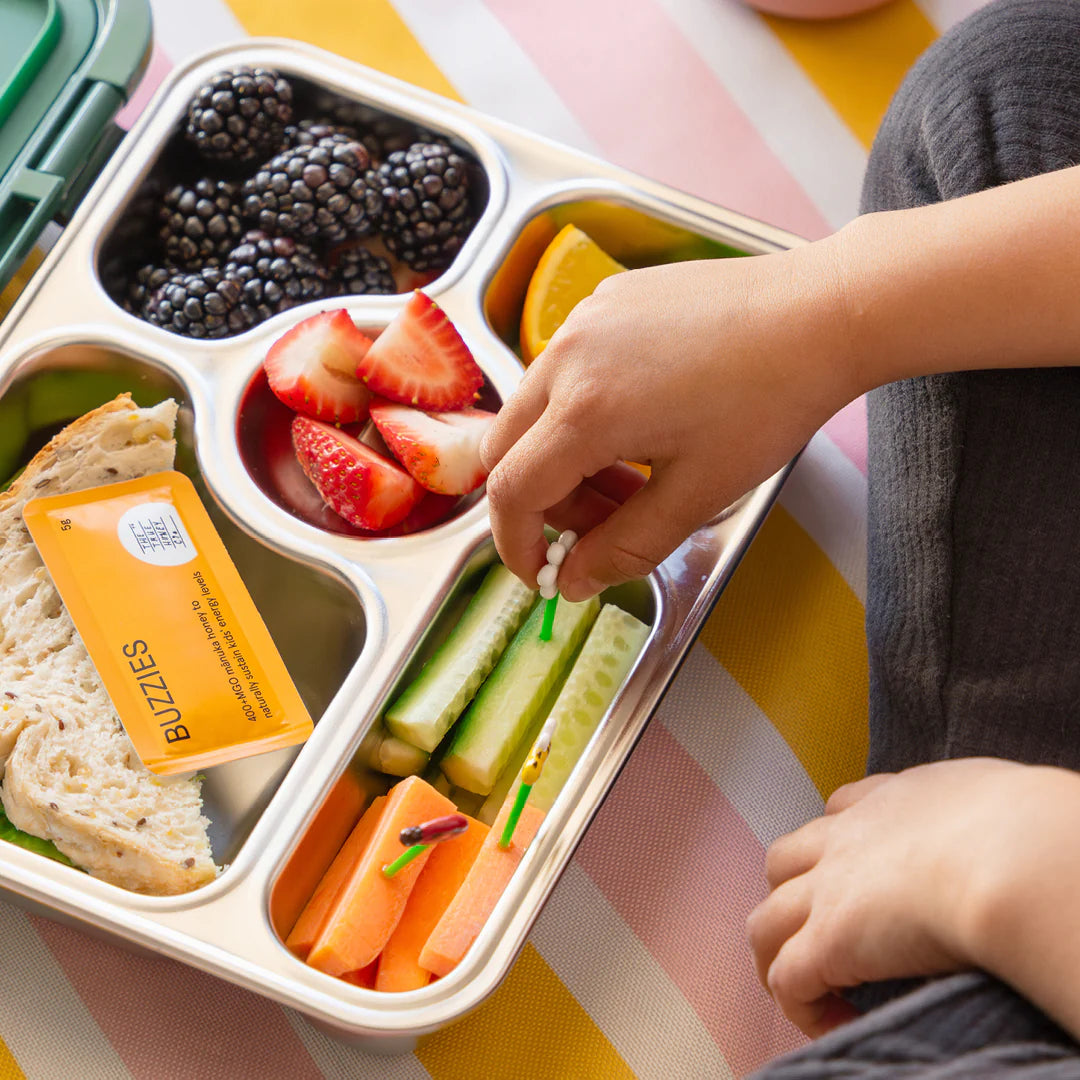 Lunchboks  et honningbrev og friske frugter, grøntsager og brød 