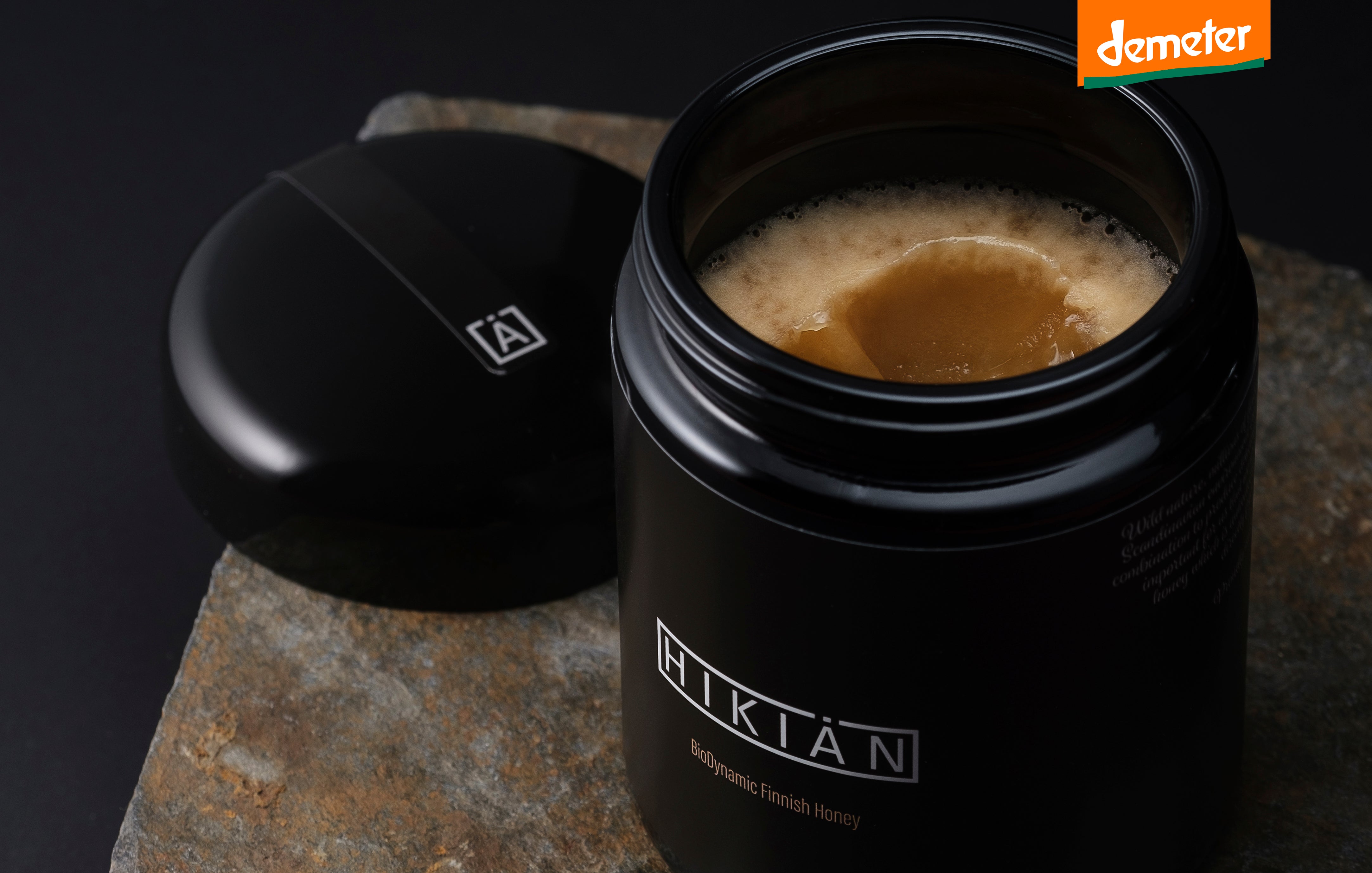 sjælden og exceptionel Hikiän – finsk honning i sin reneste form, i ekslusiv sort glas, på et bord. 