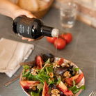 Prisvindende Muscat- og appelsinhonningeddike  fra Alemany, hældes på en salat. 