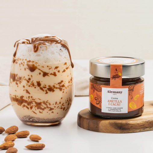 Glas Alemany mandelcreme  med honning og kakao , på bord med en fløde dessert i glas. 